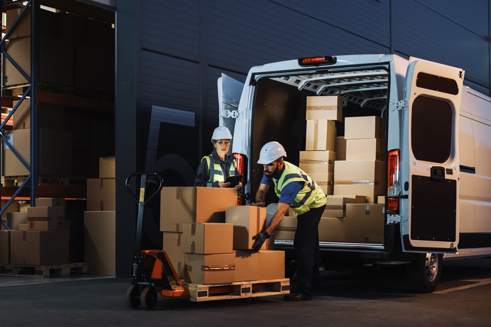 workers loading van with boxes to ship outside of warehouse