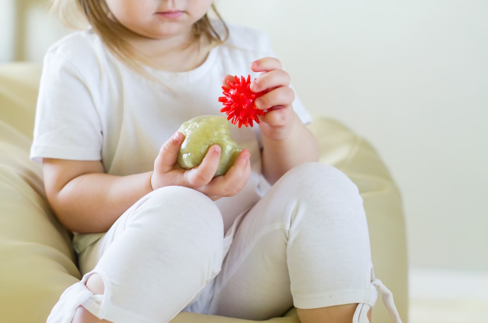 toddler holding two kinds of toys