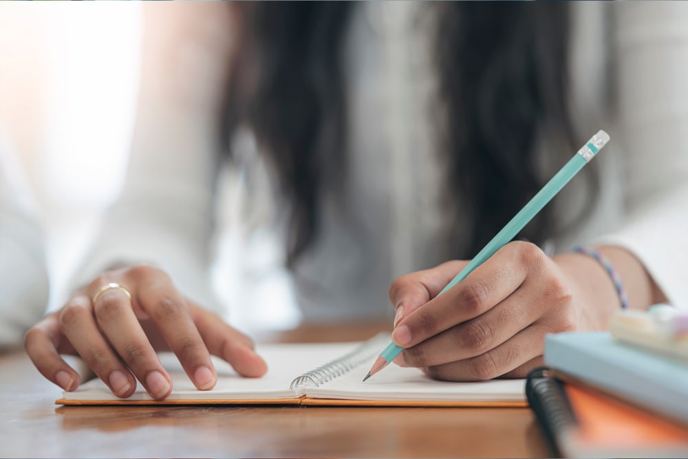 online writing mfa woman writing with pencil