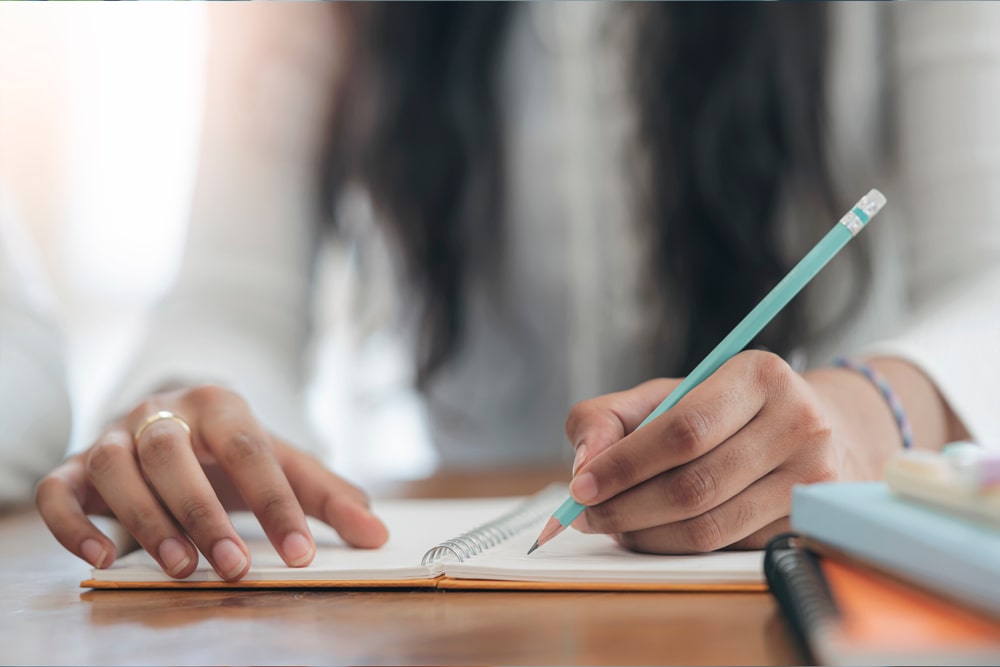 woman writing with pencil