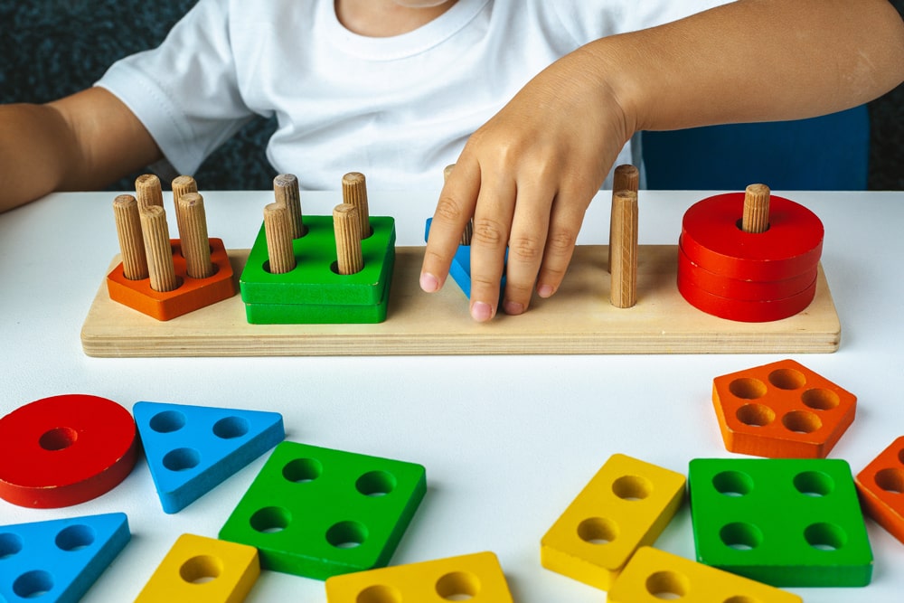 child playing with wooden educational toys
