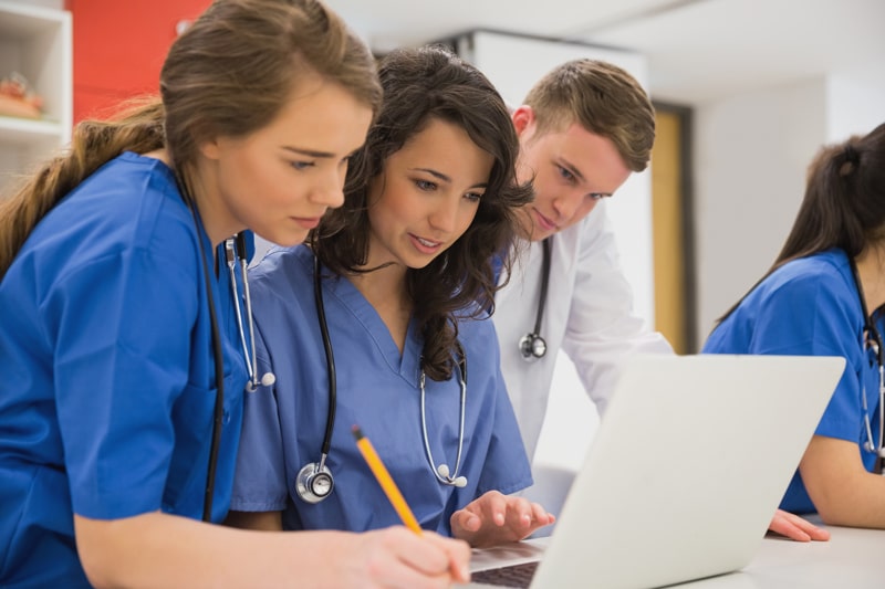 medical students working around laptop