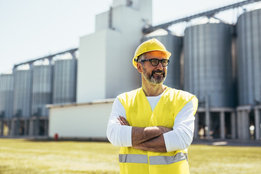man standing in front of silos