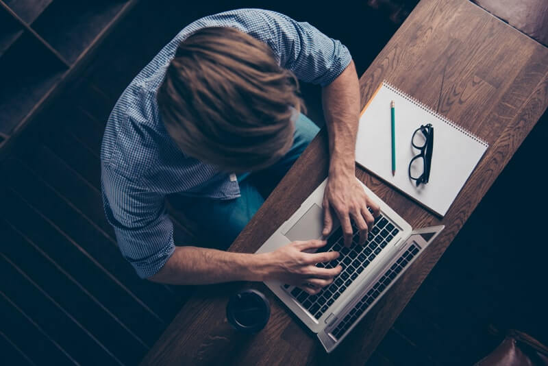 man typing on laptop