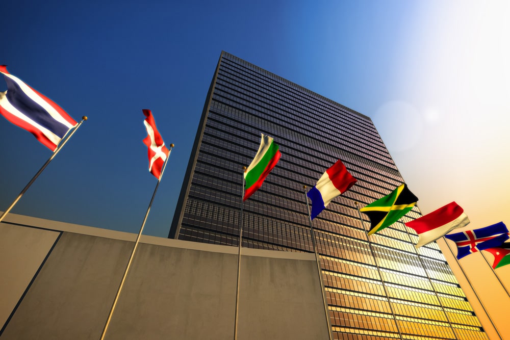 multiple country flags flying in front of building
